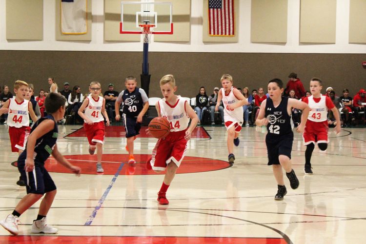 HCAMiddleSchoolBoysBasketballteamdribblestheballdowntothebasketforalayup Athletics at Haywood Christian Academy
